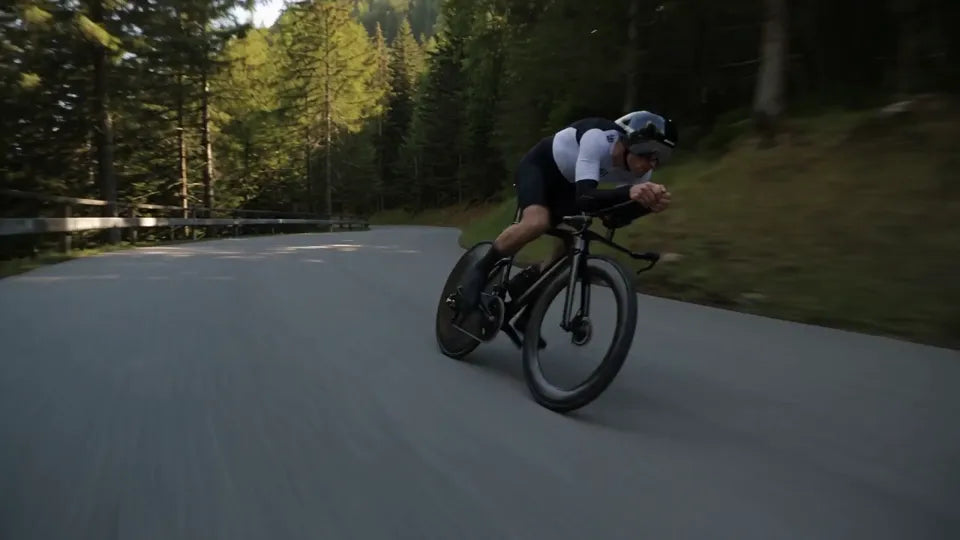 A road cyclist descending a forest road
