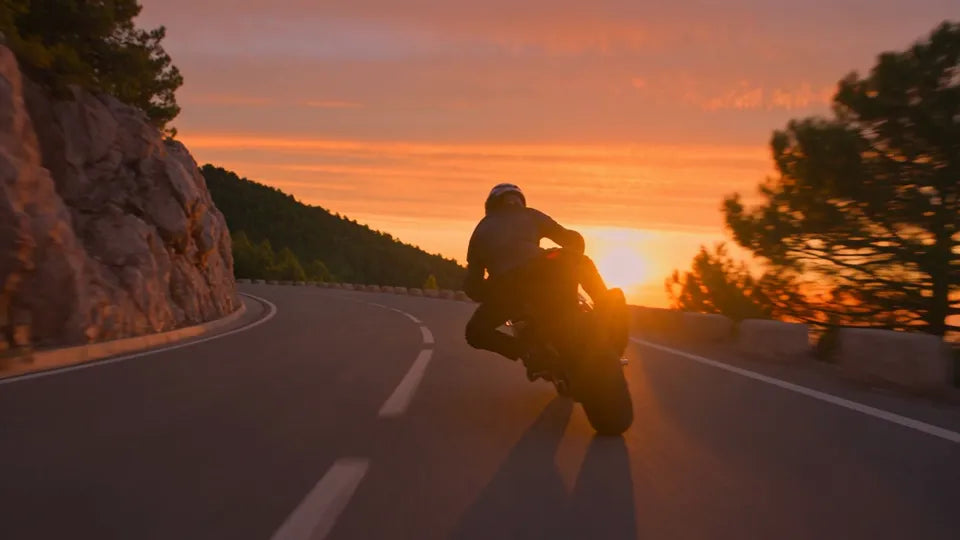 A sport bike on a coastal road at sunset